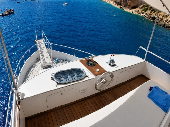 Bow of an excursion boat in Alghero with a view of the crystalline sea and the coast.