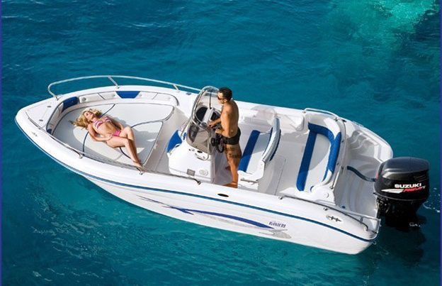 Couple enjoying the sun on a rental boat in the turquoise waters of Sardinia