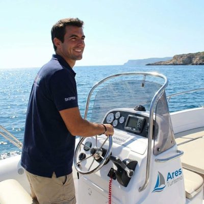 Professional Ares Turismo skipper driving a Ranieri Soverato boat during a private excursion in Alghero.